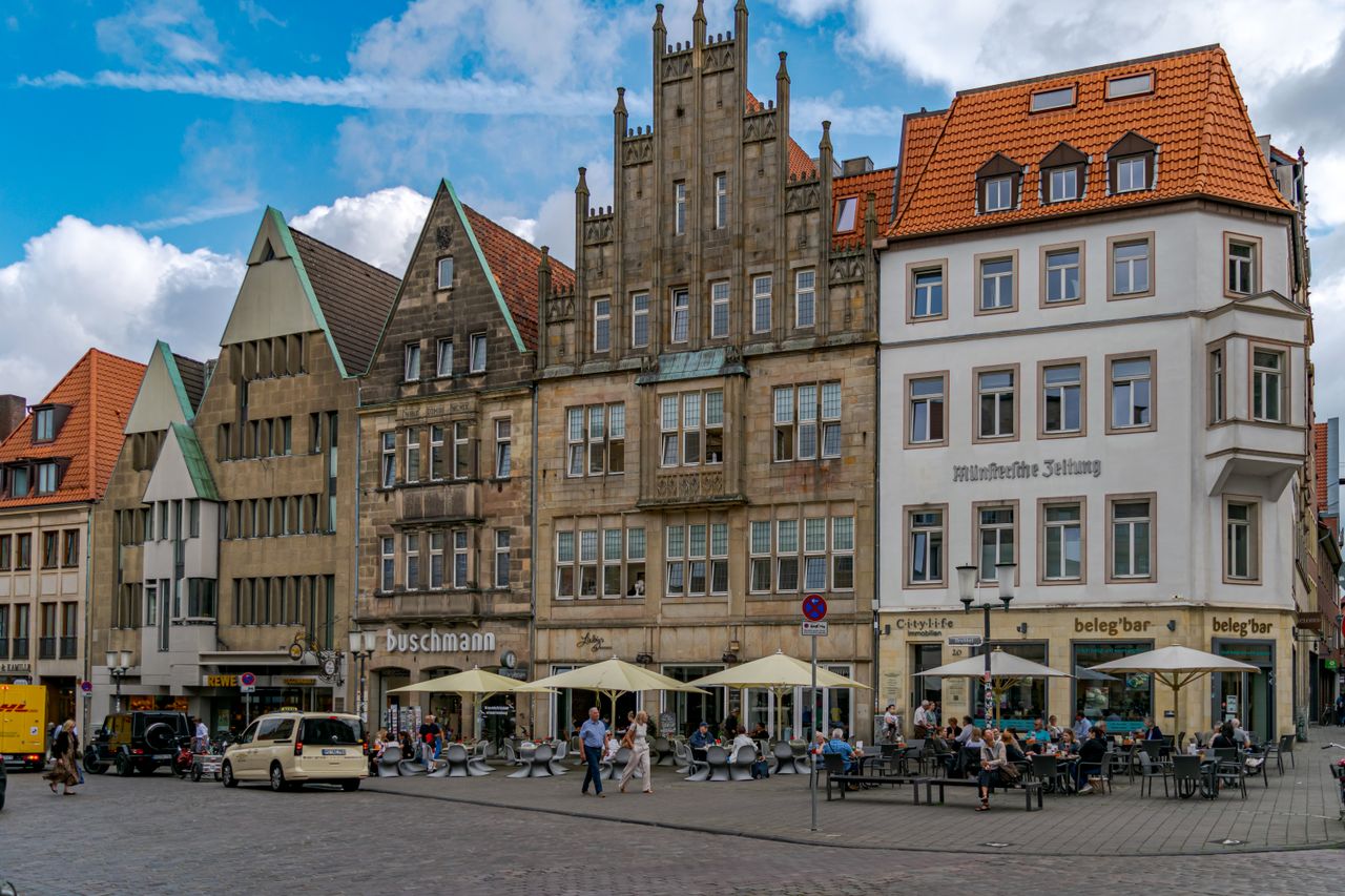 Charming street view of historic buildings and cafes in Münster, Germany.